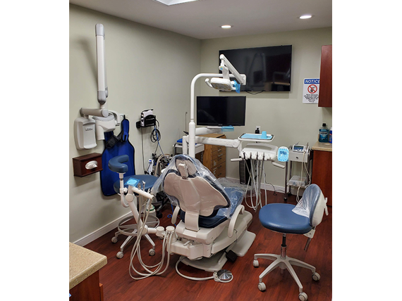 Dental office setup with dental chair, equipment, and a clean environment.