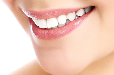 A close-up of a woman s face with a focus on her teeth, showcasing a smile and the results of dental treatment.